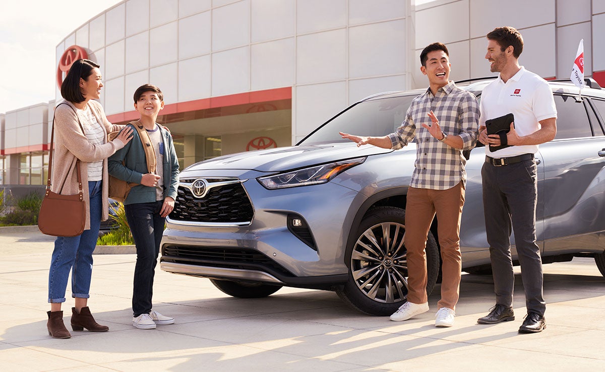 Family at a car dealership with a sales person